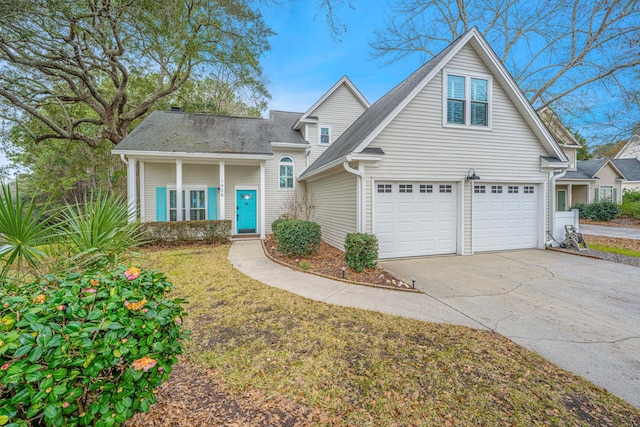 traditional-style home featuring a porch, a garage, concrete driveway, roof with shingles, and a front yard