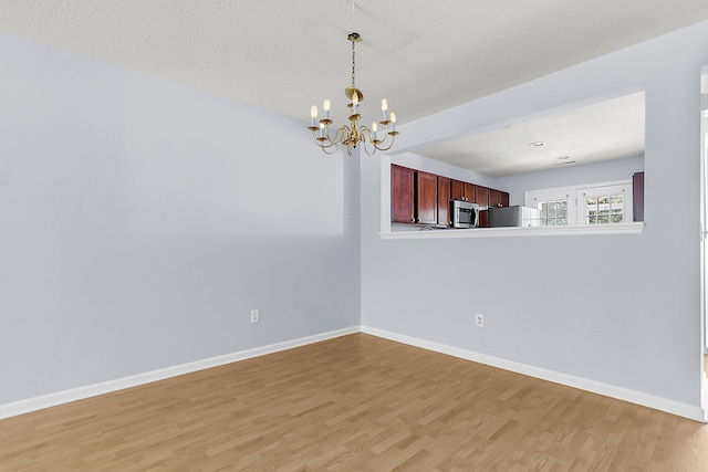 230 Darcy Ave, Goose Creek, SC 29445 - empty room featuring light wood-style flooring, a chandelier, and baseboards
