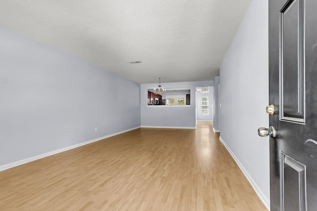 230 Darcy Ave, Goose Creek, SC 29445 - unfurnished living room featuring a chandelier, light wood-style floors, a textured ceiling, and baseboards