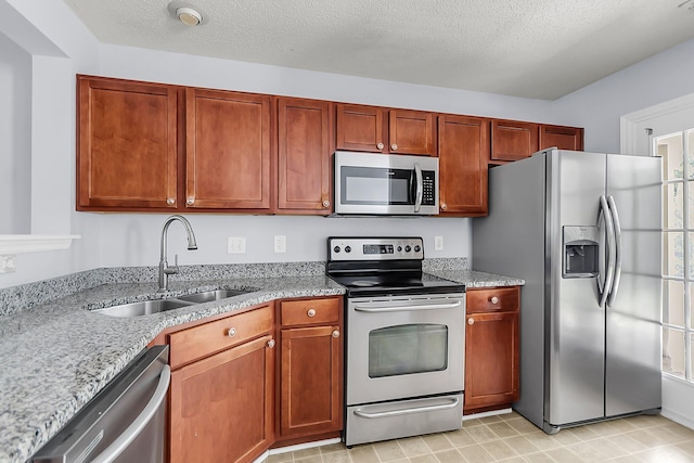 230 Darcy Ave, Goose Creek, SC 29445 - kitchen with stainless steel appliances, a sink, light stone counters, and a textured ceiling