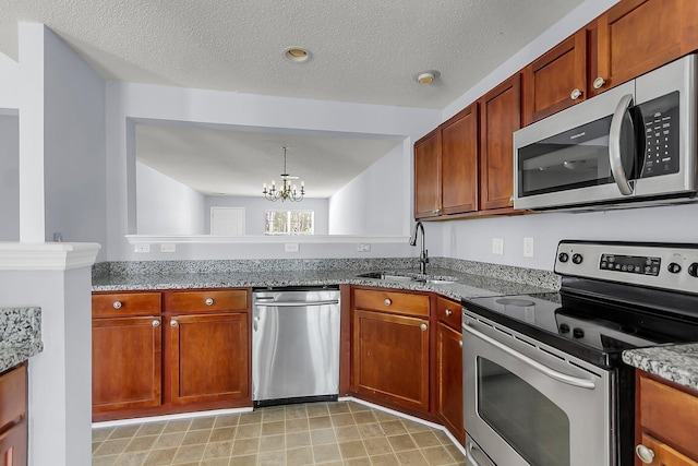 230 Darcy Ave, Goose Creek, SC 29445 - kitchen featuring stainless steel appliances, a sink, a chandelier, stone counters, and brown cabinets