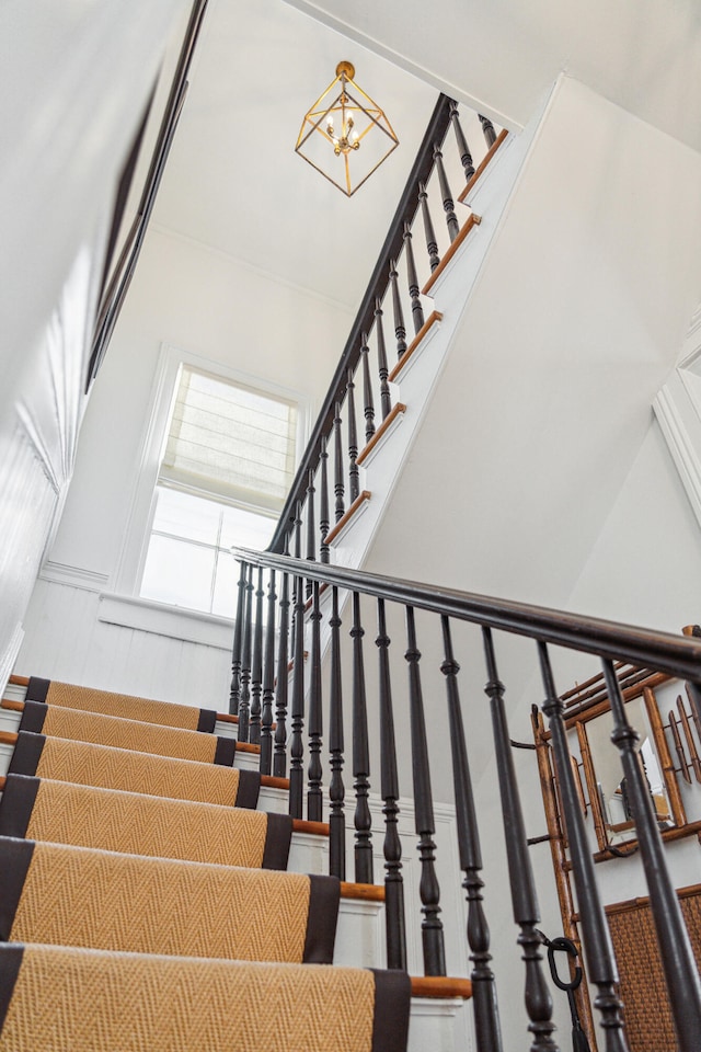 stairs featuring a high ceiling and a notable chandelier