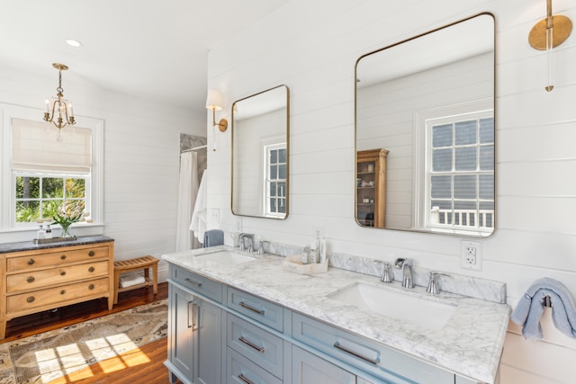 bathroom featuring wood-type flooring, vanity, wood walls, and walk in shower