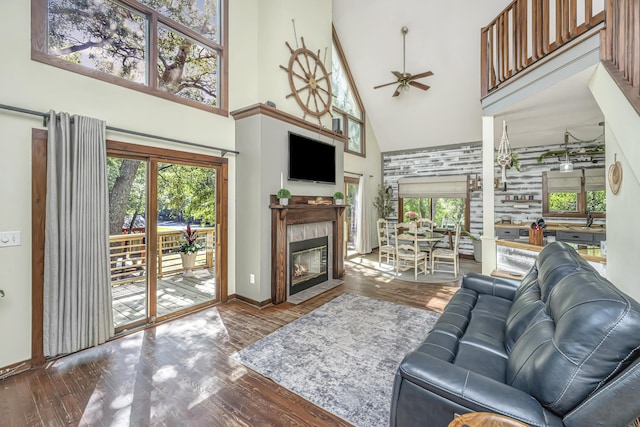 2468 Marina Rd, Wadmalaw Island, SC 29487 - living area featuring high vaulted ceiling, a ceiling fan, wood finished floors, baseboards, and a fireplace with flush hearth
