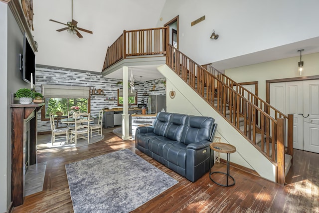 2468 Marina Rd, Wadmalaw Island, SC 29487 - living area with high vaulted ceiling, a fireplace with raised hearth, a ceiling fan, stairway, and wood finished floors