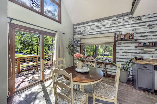 2468 Marina Rd, Wadmalaw Island, SC 29487 - dining room featuring high vaulted ceiling, wooden walls, an accent wall, and wood finished floors