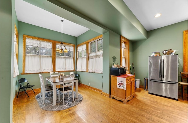 dining space with an inviting chandelier and light hardwood / wood-style floors