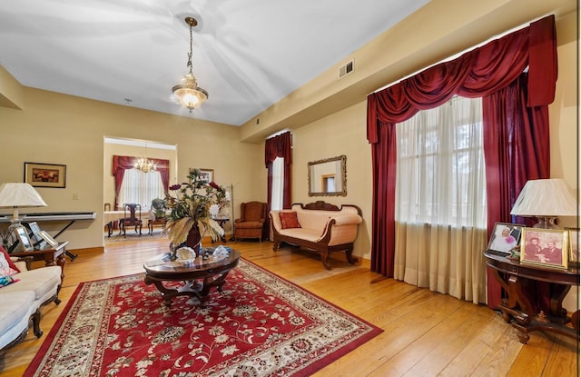 living room with a chandelier and light wood-type flooring