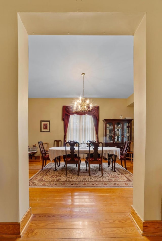 dining space with an inviting chandelier and hardwood / wood-style floors