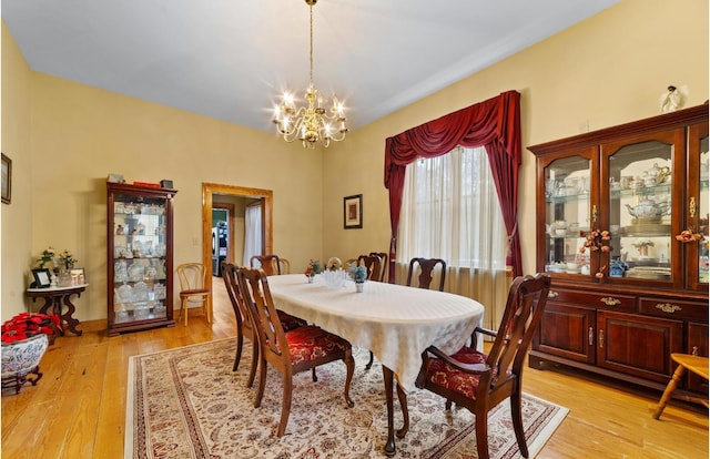 dining space featuring an inviting chandelier and light hardwood / wood-style floors