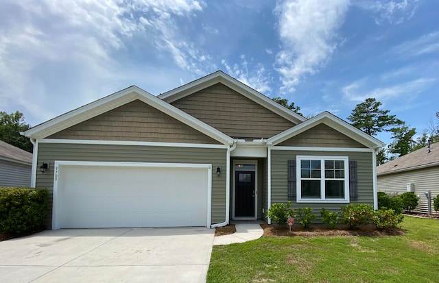 craftsman-style home featuring a front yard and a garage