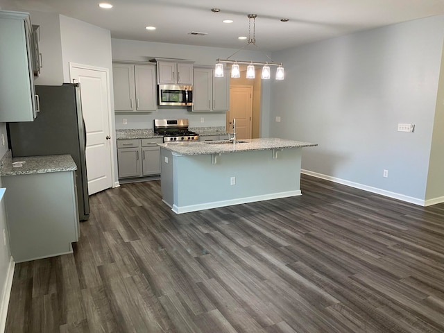 kitchen featuring appliances with stainless steel finishes, sink, pendant lighting, and dark hardwood / wood-style floors