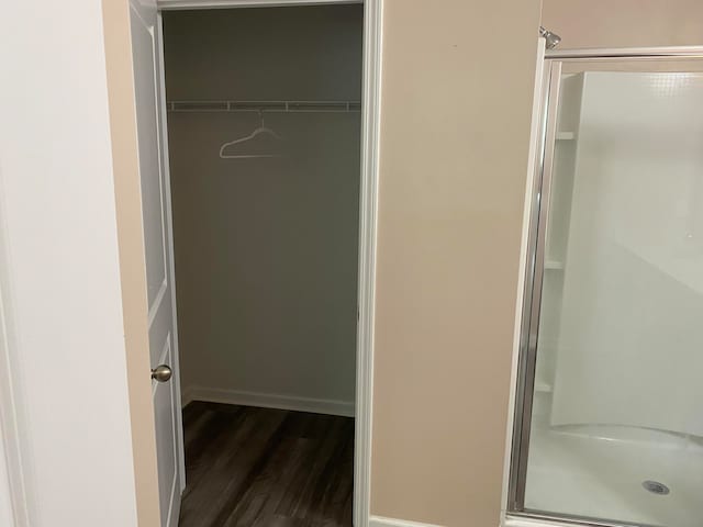 bathroom with hardwood / wood-style flooring and an enclosed shower