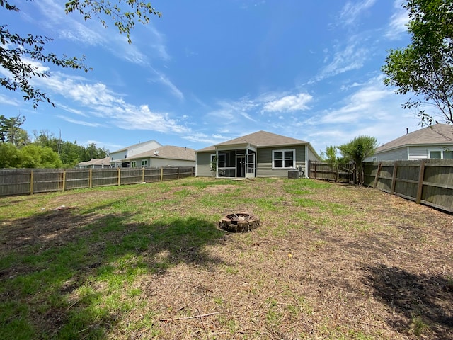 back of house featuring a sunroom and an outdoor fire pit