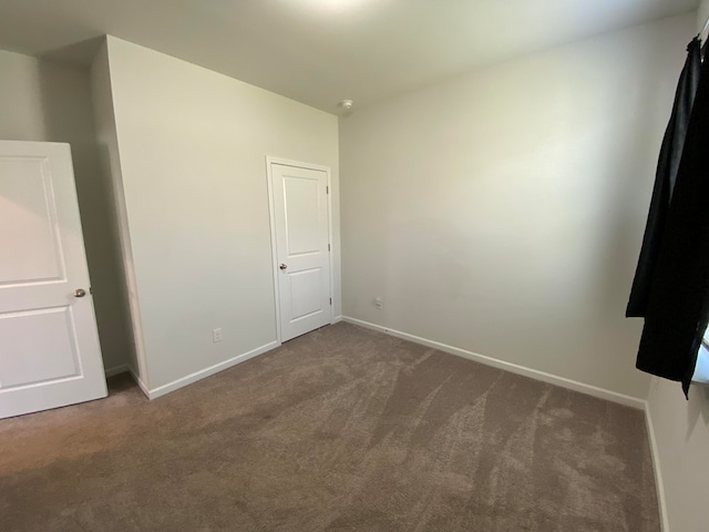 unfurnished bedroom with dark carpet