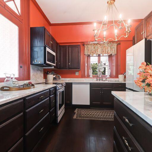 81 Rutledge Ave, Charleston, SC 29401 - kitchen featuring white appliances, a chandelier, a sink, dark wood finished floors, and ornamental molding