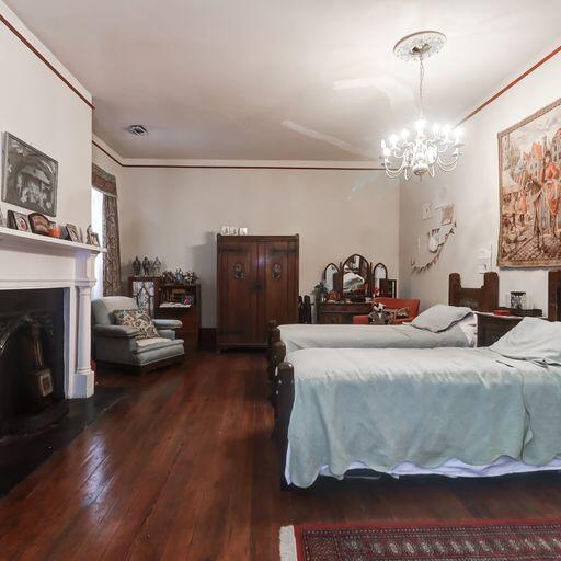81 Rutledge Ave, Charleston, SC 29401 - bedroom featuring wood-type flooring, a chandelier, crown molding, and a fireplace