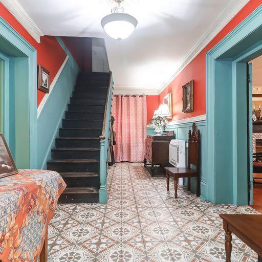 81 Rutledge Ave, Charleston, SC 29401 - staircase featuring crown molding, a wainscoted wall, and tile patterned flooring