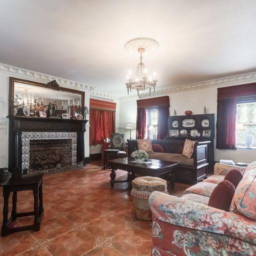 81 Rutledge Ave, Charleston, SC 29401 - living room with healthy amount of natural light, a chandelier, a tile fireplace, and tile patterned flooring