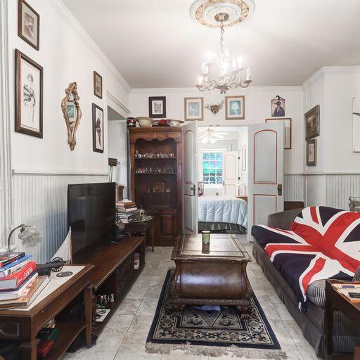 81 Rutledge Ave, Charleston, SC 29401 - living area with a chandelier, a wainscoted wall, ornamental molding, ceiling fan, and light tile patterned floors