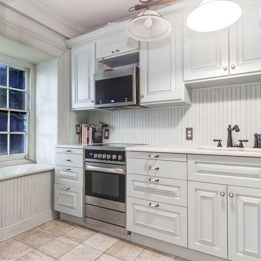 81 Rutledge Ave, Charleston, SC 29401 - kitchen with appliances with stainless steel finishes, a sink, light countertops, and white cabinets
