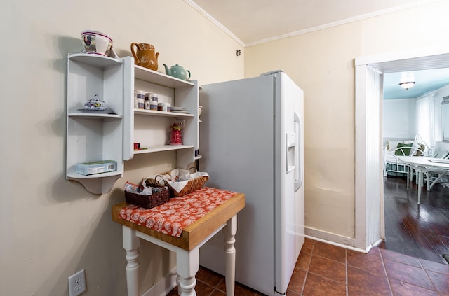 81 Rutledge Ave, Charleston, SC 29401 - kitchen featuring white refrigerator with ice dispenser, ornamental molding, baseboards, and dark tile patterned flooring