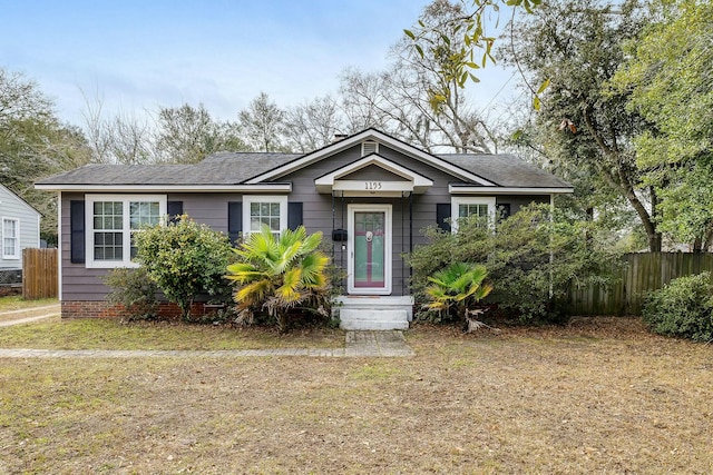 bungalow-style home featuring a front yard and fence