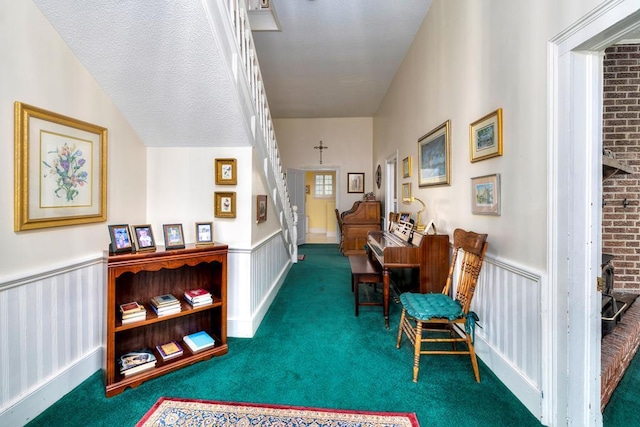 hall with carpet, lofted ceiling, and a textured ceiling