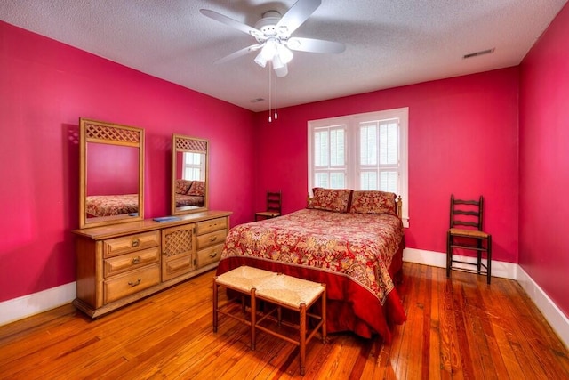 bedroom featuring ceiling fan, a textured ceiling, and hardwood / wood-style flooring