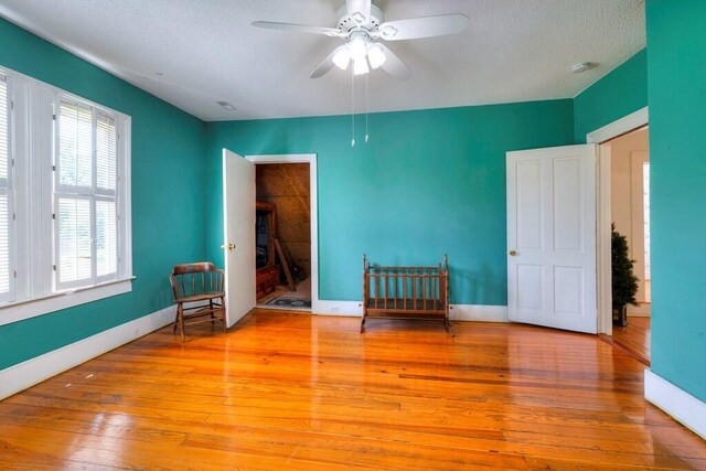 interior space featuring ceiling fan, a textured ceiling, and light wood-type flooring