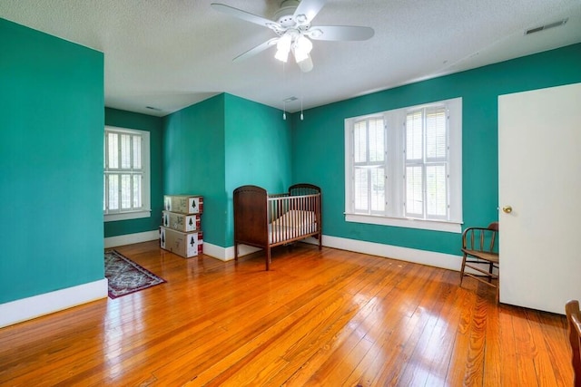 sitting room featuring ceiling fan, a textured ceiling, and light wood-type flooring