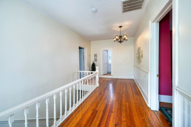 hallway with a chandelier and dark hardwood / wood-style floors