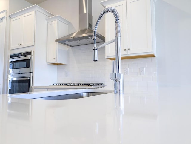 444 Parish Farms Dr, Summerville, SC 29486 - kitchen featuring stainless steel appliances, wall chimney exhaust hood, white cabinetry, tasteful backsplash, and light countertops