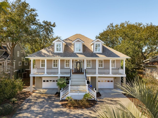 raised beach house with driveway, a garage, stairs, and a porch