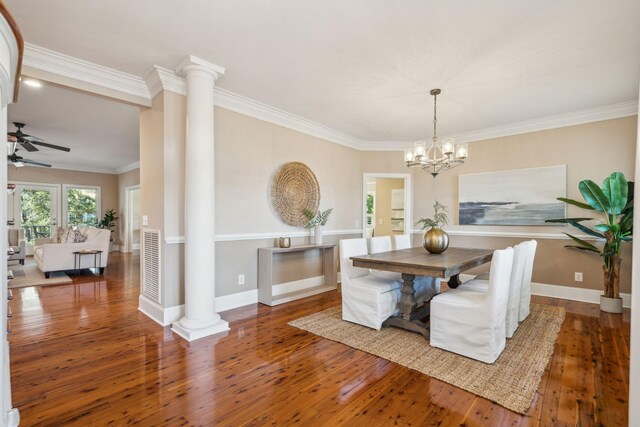 dining room with crown molding, wood-type flooring, decorative columns, and baseboards