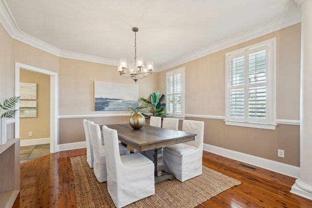 dining space featuring a chandelier, hardwood / wood-style floors, visible vents, and baseboards