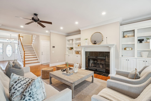 living room with light wood finished floors, baseboards, a fireplace, and stairway