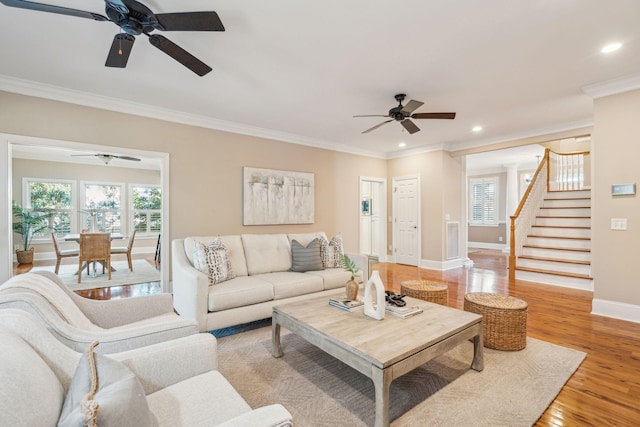 living area featuring baseboards, stairs, crown molding, light wood-style floors, and recessed lighting