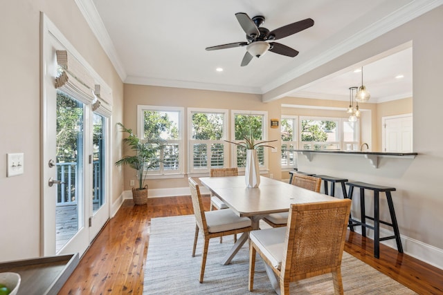 dining area featuring ornamental molding, baseboards, and hardwood / wood-style floors