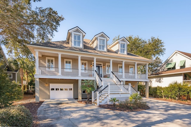 beach home featuring stucco siding, a porch, stairway, an attached garage, and driveway