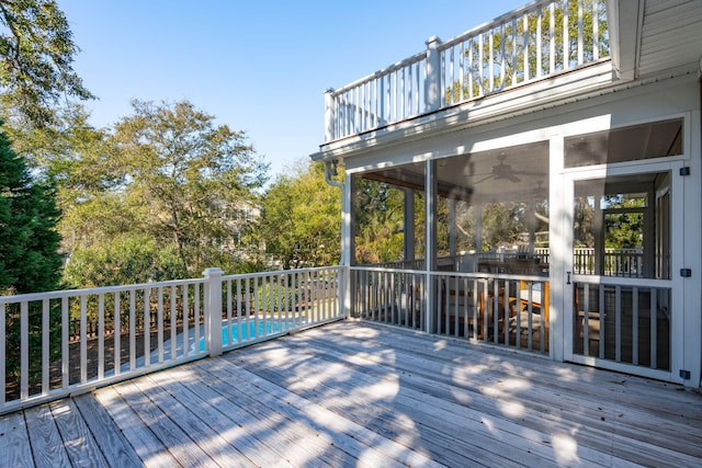 wooden terrace with a fenced in pool and a sunroom