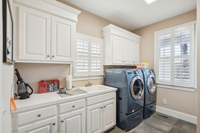 laundry room featuring cabinet space, visible vents, baseboards, washing machine and dryer, and a sink