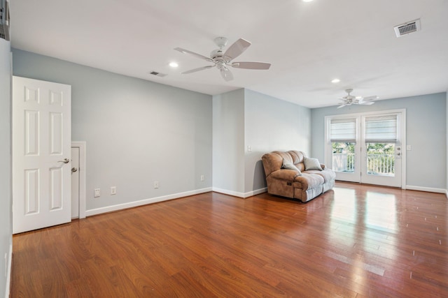 unfurnished room with baseboards, visible vents, and wood finished floors