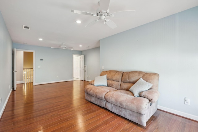 living room featuring visible vents, baseboards, wood finished floors, and recessed lighting