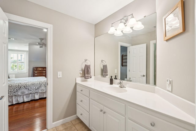 bathroom with a ceiling fan, vanity, ensuite bath, baseboards, and tile patterned floors