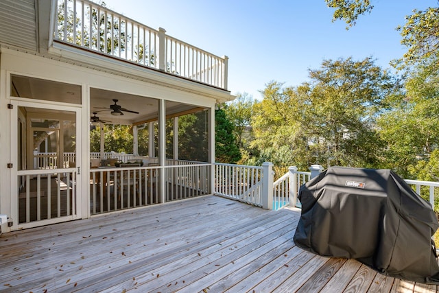 wooden deck with a sunroom, grilling area, and a ceiling fan