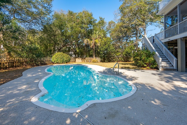 view of swimming pool featuring a fenced backyard, stairway, a fenced in pool, and a patio