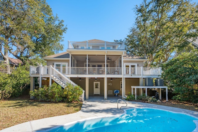 back of property featuring a balcony, stairs, a ceiling fan, and a wooden deck