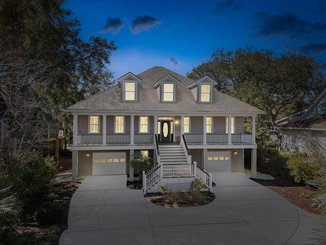 beach home featuring driveway, stairs, a porch, and stucco siding