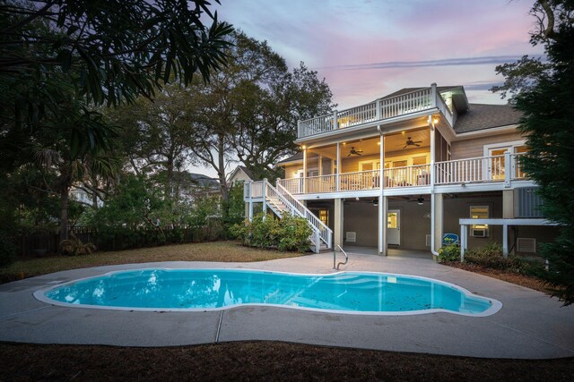 view of swimming pool featuring ceiling fan, stairway, a fenced in pool, and a patio